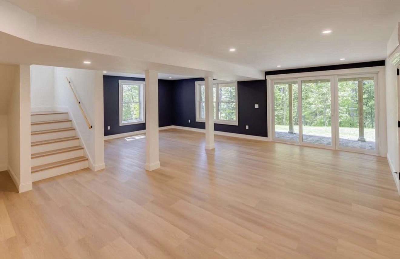 Bright finished walk-out lower level with white oak flooring in a custom NH home