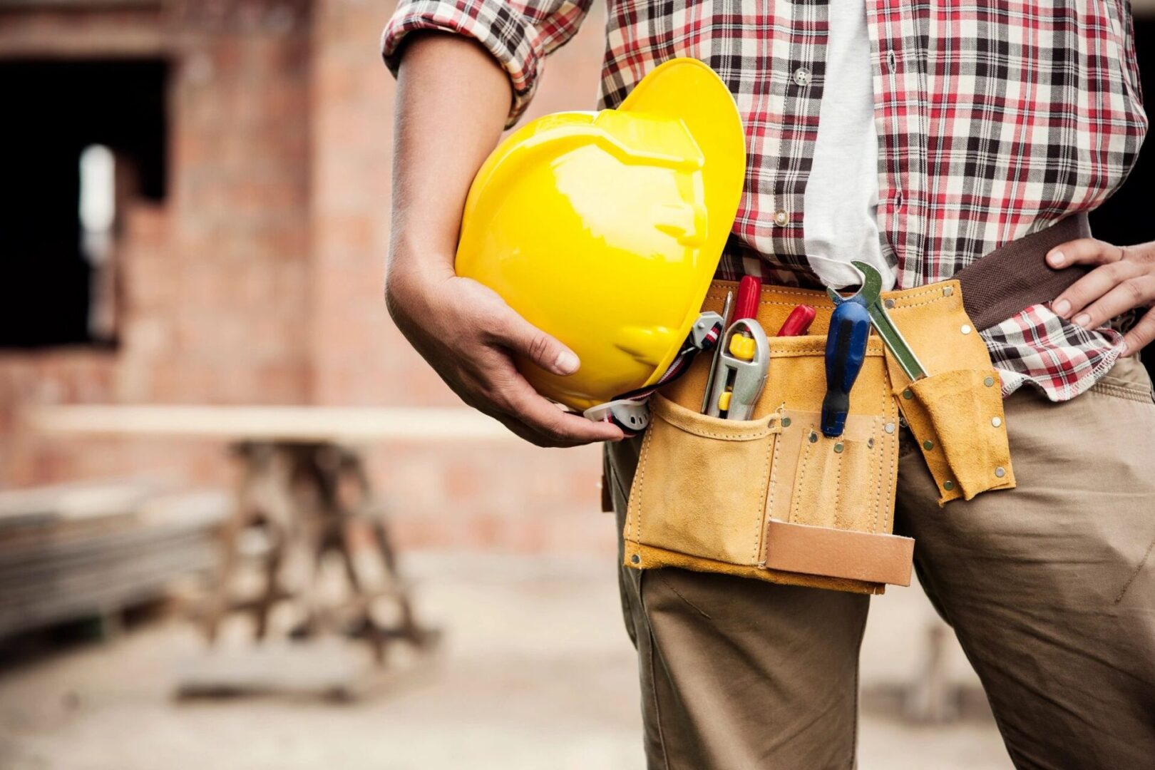 A person standing while holding a hard hat